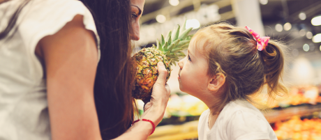 Junge Leute: Kleinkinder - Mädchen schaut Frau mit Ananas in der Hand an | Sparkasse Hannover