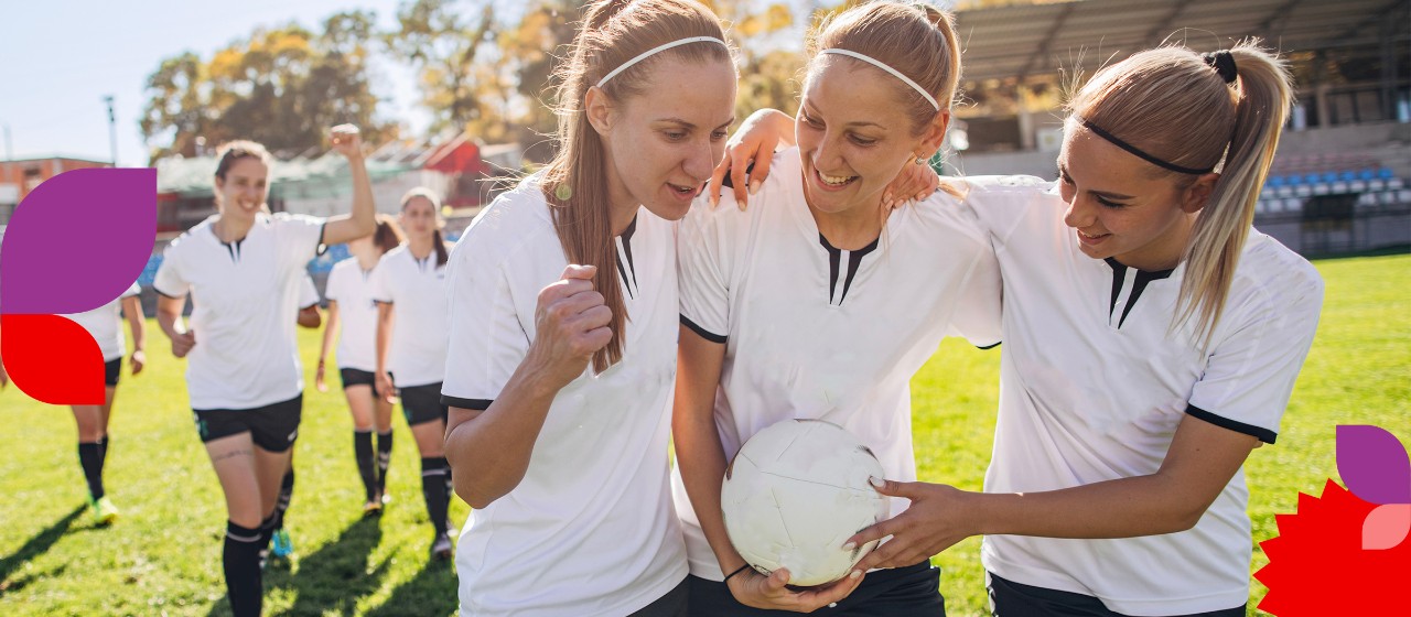 Drei Frauen aus einem Fußball-Team stehen zusammen und freuen sich | Sparkasse Hannover